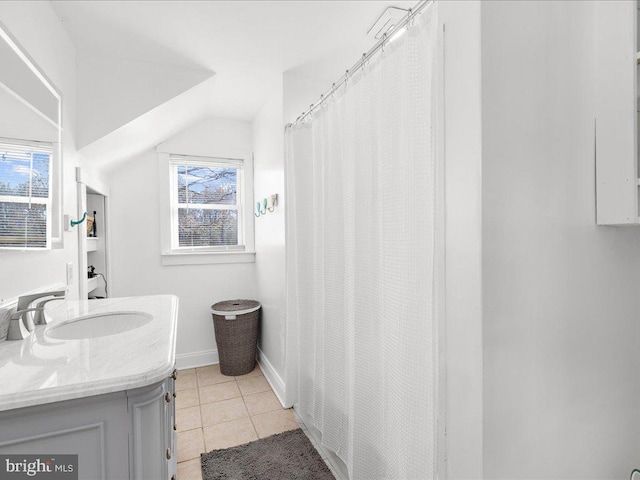 bathroom featuring vanity, lofted ceiling, and tile patterned floors