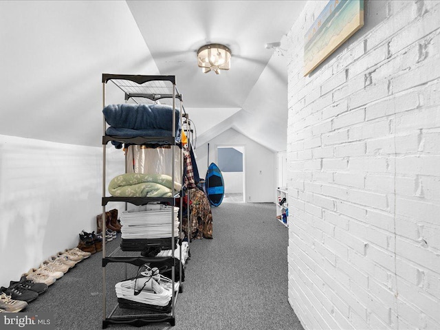 exercise room with lofted ceiling, brick wall, and carpet floors