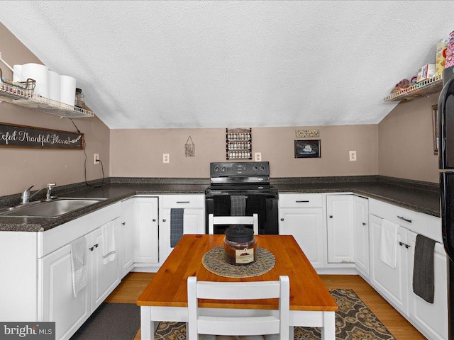 kitchen with black range with electric cooktop, a textured ceiling, sink, and white cabinets