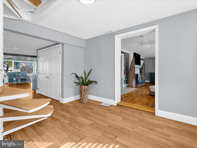 corridor featuring ceiling fan and light wood-type flooring