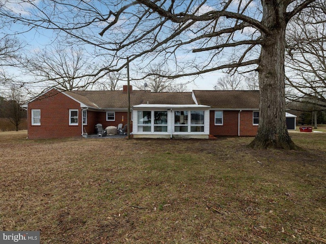 back of house featuring a sunroom and a yard