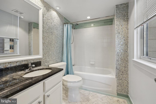 full bathroom featuring shower / tub combo with curtain, toilet, tile walls, vanity, and decorative backsplash