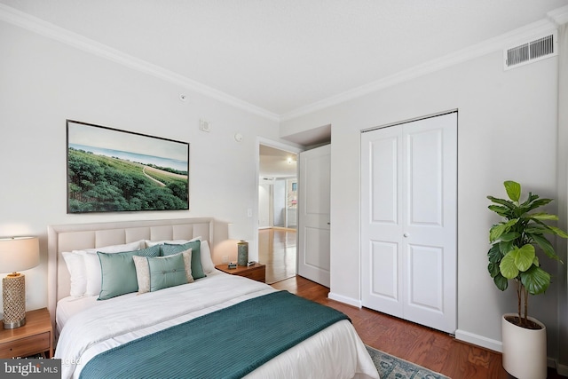 bedroom with crown molding, dark hardwood / wood-style floors, and a closet