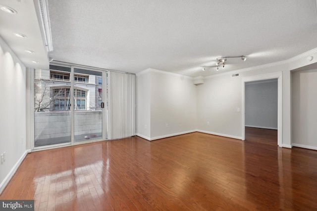 unfurnished room with ornamental molding, floor to ceiling windows, wood-type flooring, and a textured ceiling