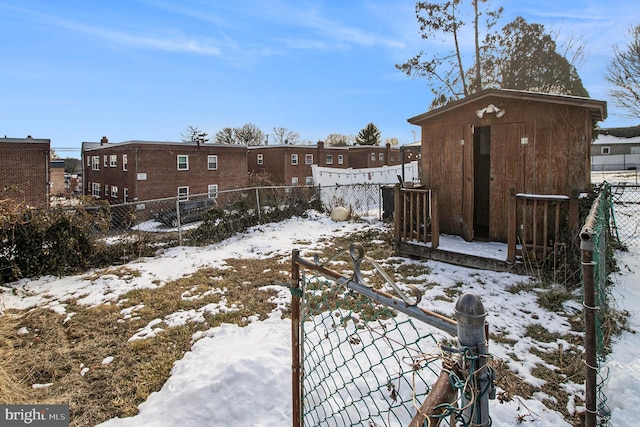 yard covered in snow featuring a storage shed