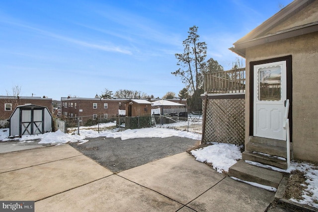 snow covered patio with a storage unit