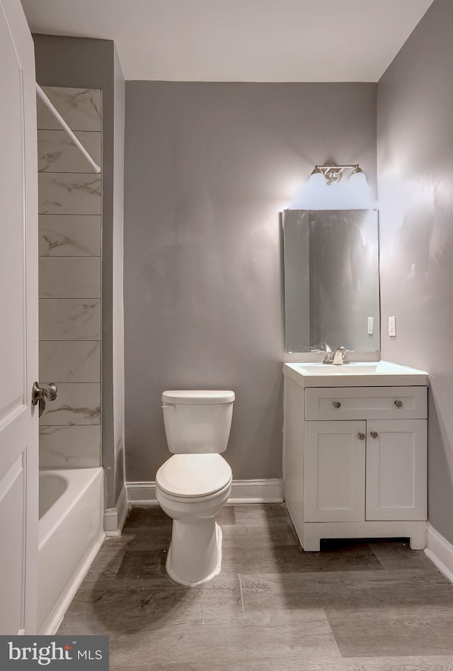 bathroom featuring wood-type flooring, toilet, and vanity