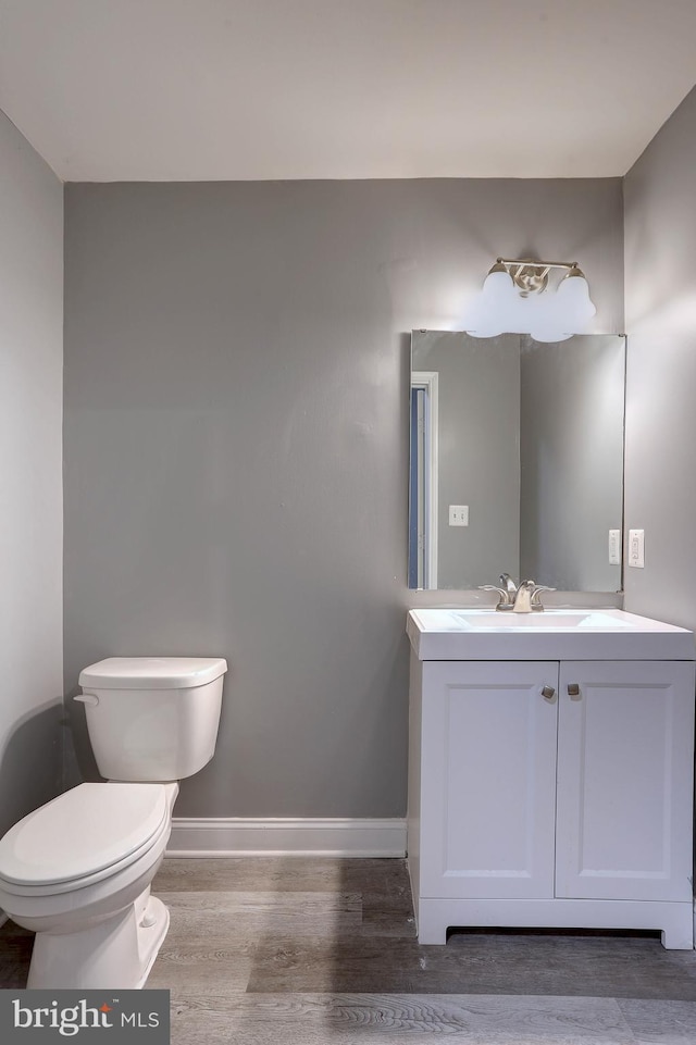 bathroom with vanity, wood-type flooring, and toilet