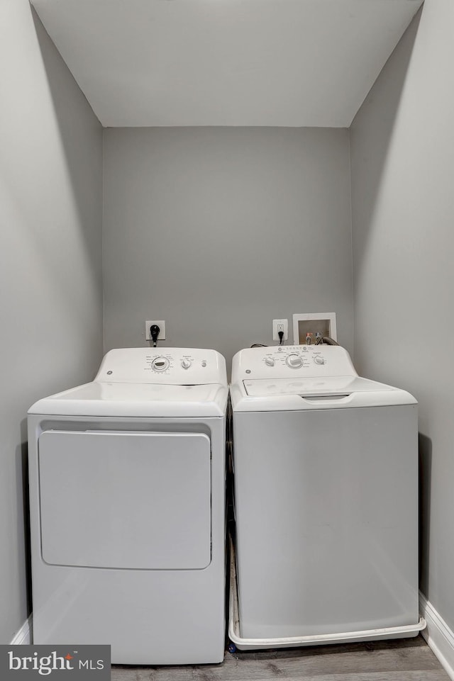 washroom with hardwood / wood-style flooring and washer and dryer