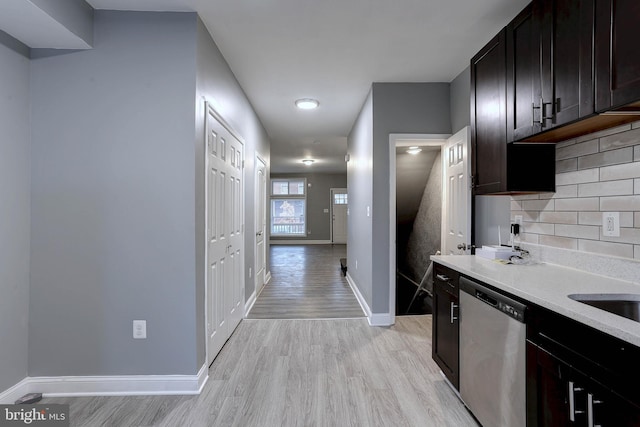 kitchen featuring dishwasher, decorative backsplash, dark brown cabinetry, and light hardwood / wood-style flooring