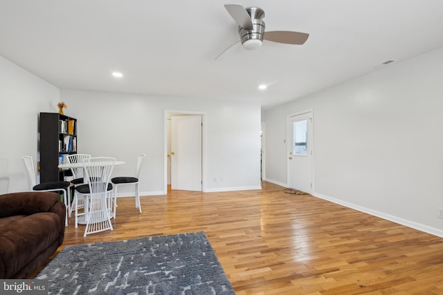 living room featuring ceiling fan and light hardwood / wood-style flooring