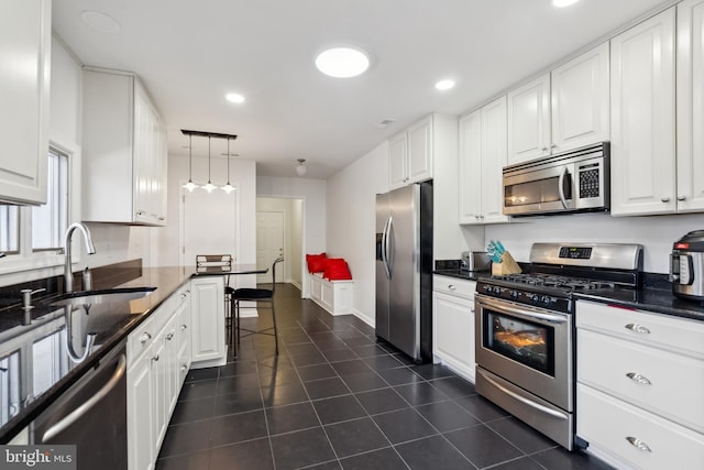 kitchen with stainless steel appliances, sink, hanging light fixtures, and white cabinets