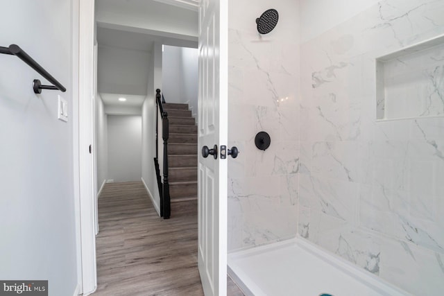 bathroom with hardwood / wood-style flooring and tiled shower