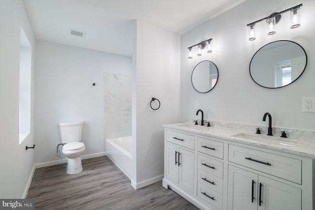 full bathroom with vanity, hardwood / wood-style flooring, toilet, and washtub / shower combination