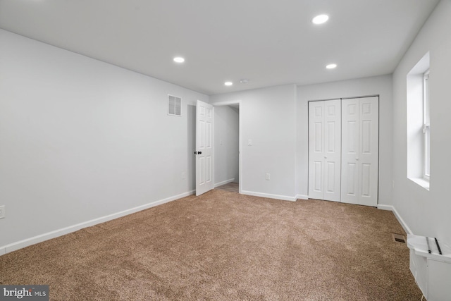 unfurnished bedroom featuring carpet floors and a closet