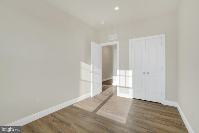 unfurnished bedroom with hardwood / wood-style floors and a closet