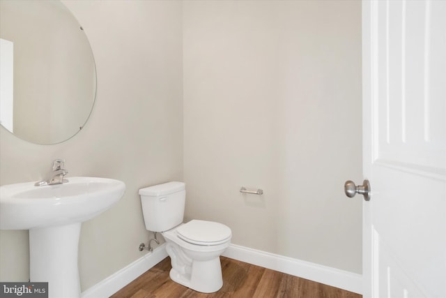 bathroom with sink, wood-type flooring, and toilet