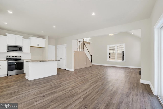 kitchen featuring white cabinetry, decorative backsplash, hardwood / wood-style flooring, a center island, and stainless steel appliances