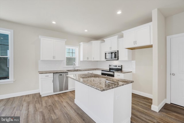 kitchen with white cabinetry, sink, a kitchen island, and appliances with stainless steel finishes