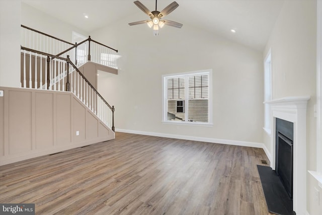 unfurnished living room with ceiling fan, high vaulted ceiling, and light hardwood / wood-style floors