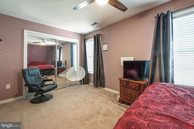 carpeted bedroom with ceiling fan and a closet