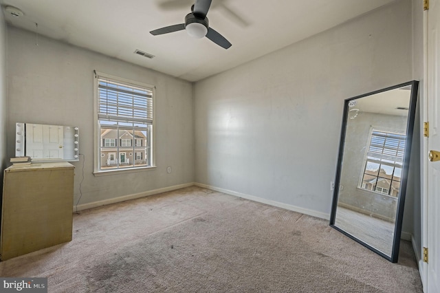 spare room with ceiling fan and light colored carpet