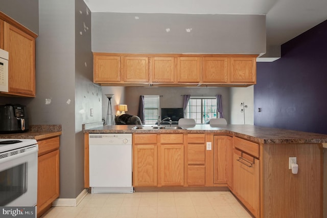 kitchen with sink, white appliances, and kitchen peninsula