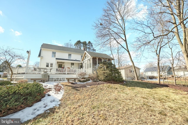 view of front of home with a deck and a front yard