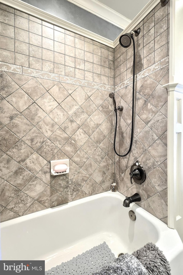 bathroom with tiled shower / bath combo and crown molding