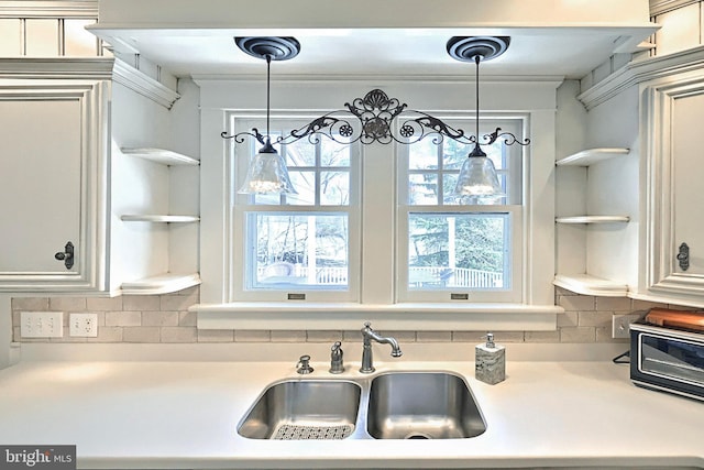 kitchen with pendant lighting, sink, and backsplash