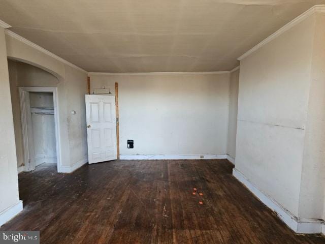 empty room with crown molding and dark hardwood / wood-style floors