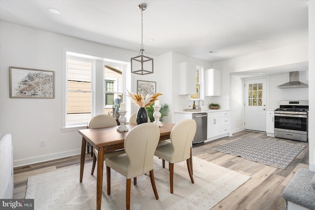 dining area featuring sink and light hardwood / wood-style flooring