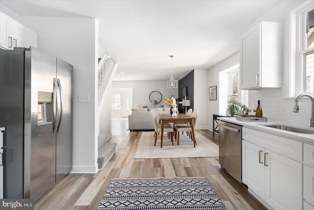 kitchen with white cabinetry, sink, backsplash, and stainless steel appliances