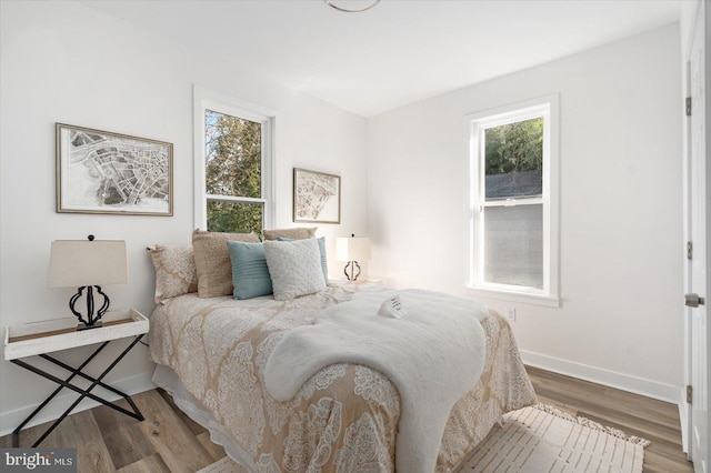 bedroom with multiple windows and wood-type flooring