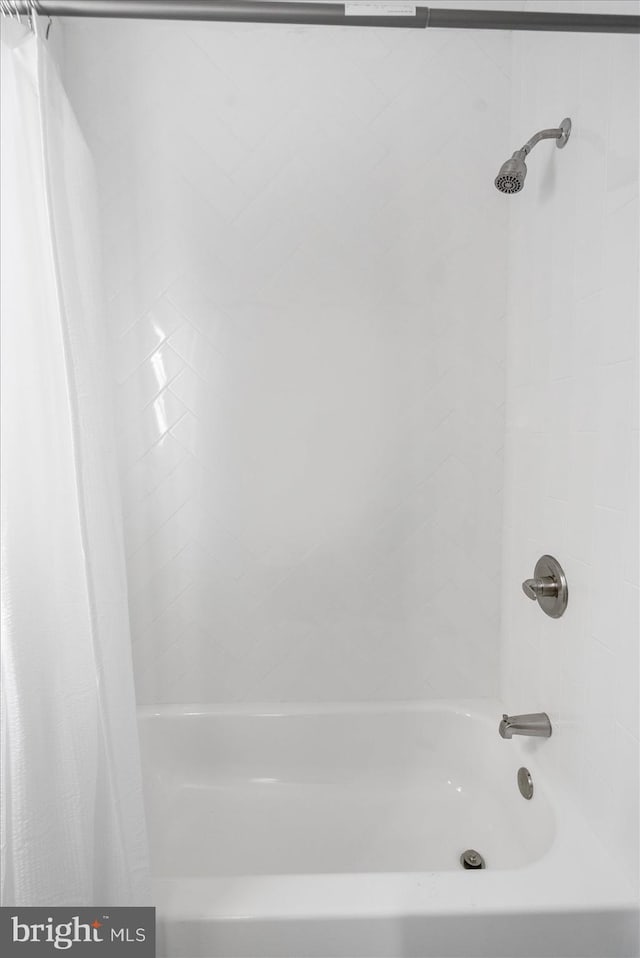 bathroom with shower / bath combo with shower curtain