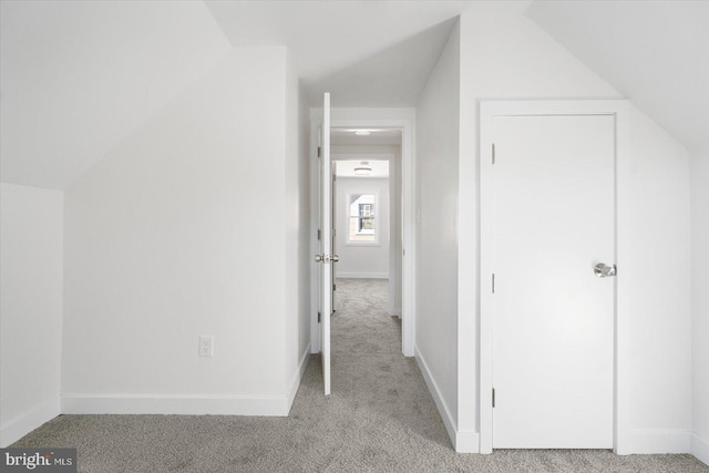 additional living space with vaulted ceiling and light carpet