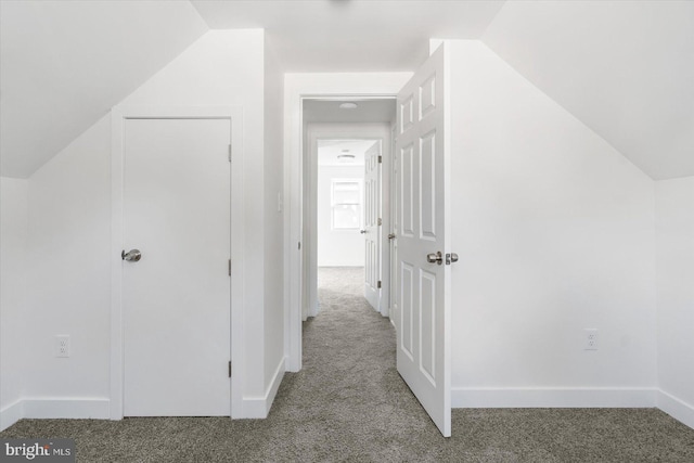 bonus room with vaulted ceiling and carpet floors