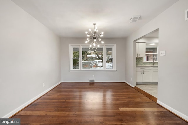 unfurnished dining area featuring hardwood / wood-style flooring and a chandelier