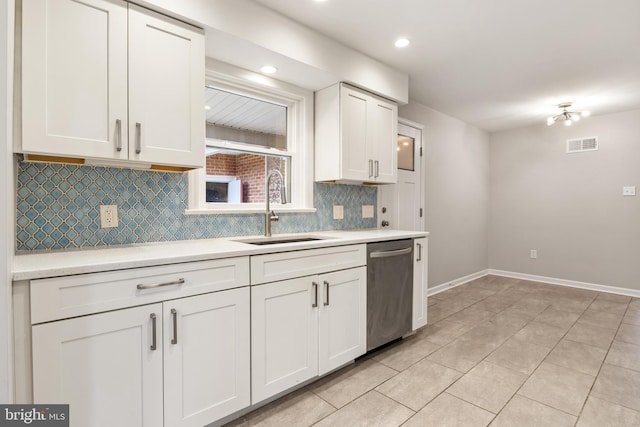 kitchen featuring light tile patterned floors, sink, dishwasher, backsplash, and white cabinets