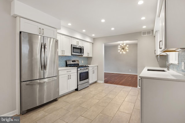 kitchen featuring white cabinetry, stainless steel appliances, sink, and tasteful backsplash