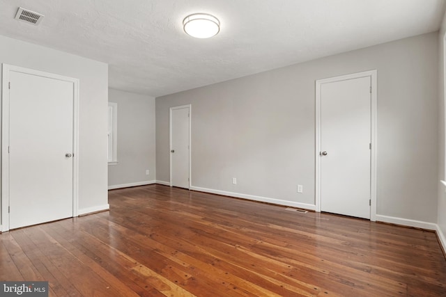 unfurnished room featuring dark hardwood / wood-style floors and a textured ceiling