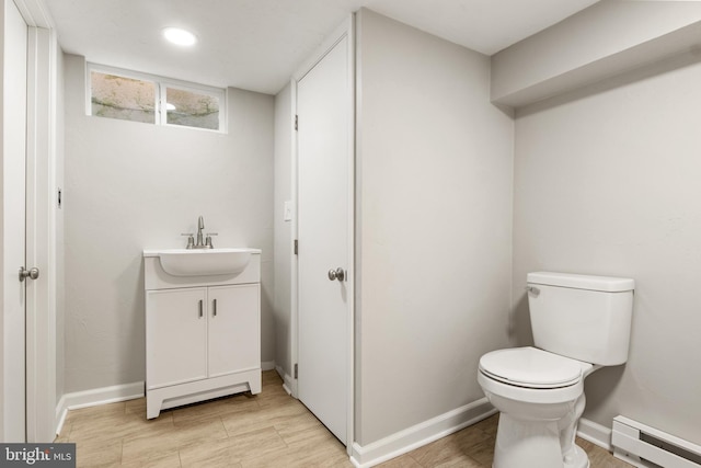 bathroom with a baseboard radiator, vanity, and toilet