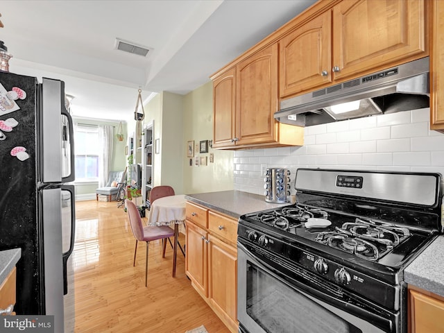 kitchen featuring tasteful backsplash, stainless steel appliances, and light wood-type flooring