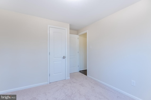 unfurnished bedroom featuring baseboards and carpet