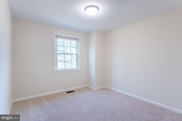 carpeted spare room with baseboards and visible vents