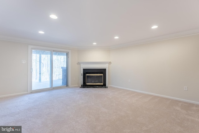 unfurnished living room with a fireplace with flush hearth, baseboards, light carpet, and crown molding