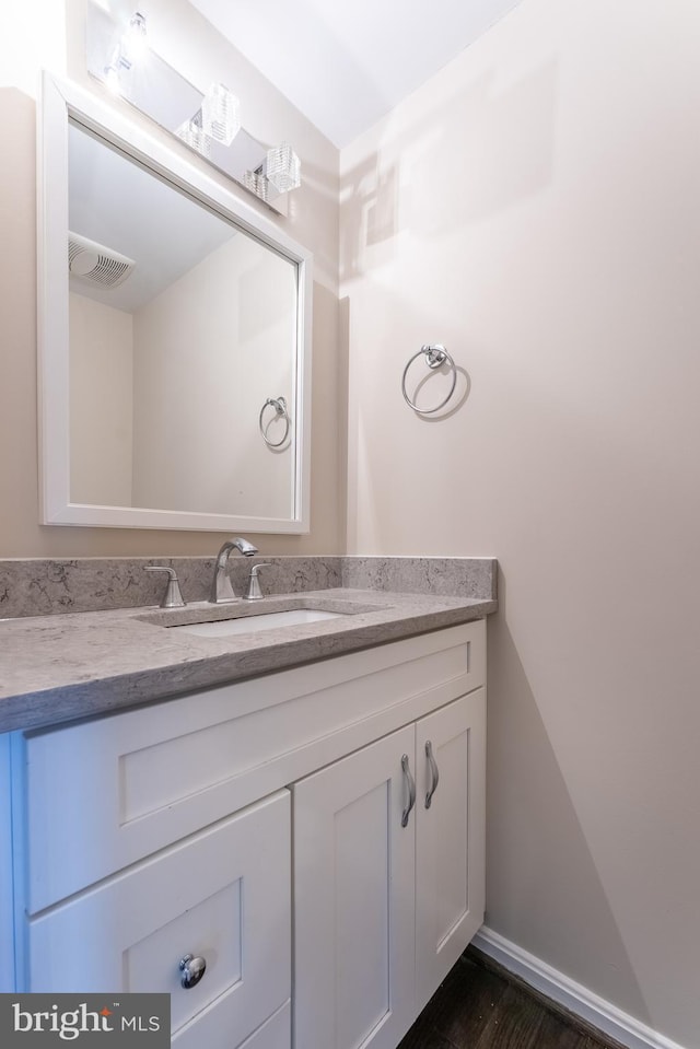 bathroom with vanity, baseboards, and visible vents