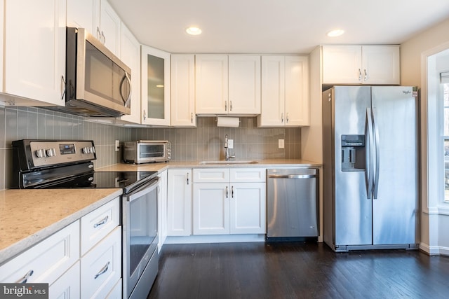 kitchen with a sink, dark wood finished floors, white cabinetry, appliances with stainless steel finishes, and a toaster