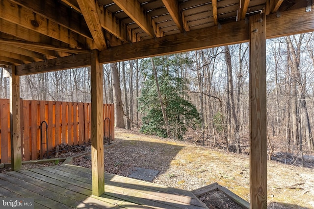 view of yard with a wooded view and fence