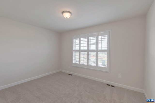 spare room featuring light carpet